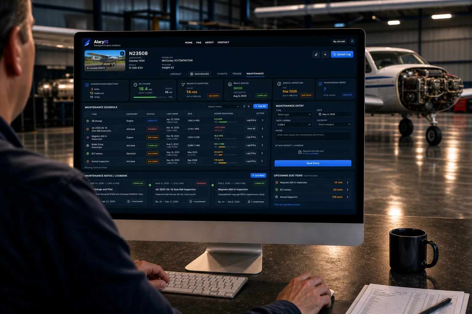 AlaryIQ maintenance dashboard displayed on a desktop monitor inside an aircraft hangar